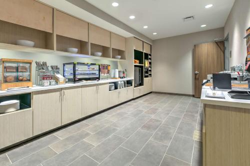 a large kitchen with cabinets and a counter at Home2 Suites By Hilton Tulsa Airport in Tulsa