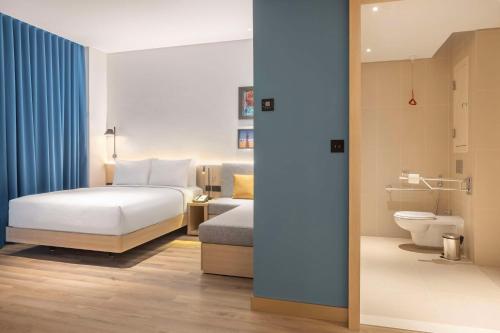 a hotel room with a bed and a toilet at Hampton By Hilton Kuwait Salmiya in Kuwait