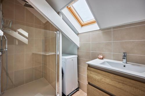 une salle de bain avec un lavabo et une machine à laver dans l'établissement Au Jardin de Mel - Appt à moins d'1 km de la plage, à Courseulles-sur-Mer