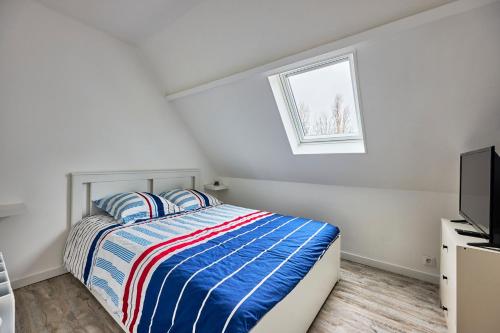 une chambre blanche avec un lit et une télévision dans l'établissement Au Jardin de Mel - Appt à moins d'1 km de la plage, à Courseulles-sur-Mer