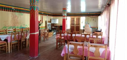 una sala da pranzo con tavoli e sedie in legno di Saser Camp a Valle di Nubra