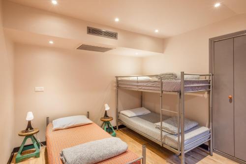 a room with two bunk beds and two lamps at Villa Saint Exupery Beach Hostel in Nice