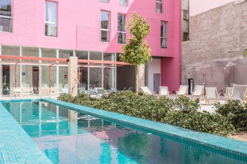 a swimming pool in front of a pink building at Password to Madrid Casa de Campo in Madrid