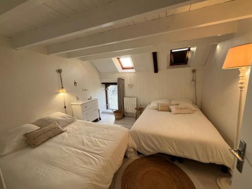 une chambre avec deux lits et une lampe dans l'établissement Maison de pêcheur - Golfe du Morbihan, à Saint-Gildas-de-Rhuys