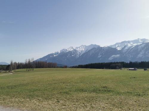 a large green field with mountains in the background at Carina's Apartment in Obsteig