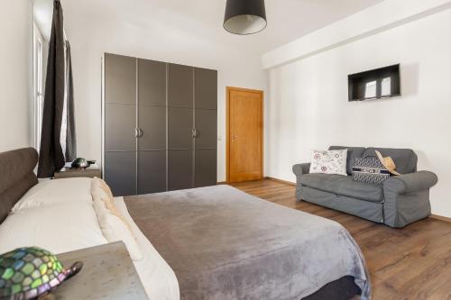 a bedroom with a bed and a couch in it at Guest House Maison 6 in Lido di Ostia