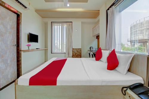 a bedroom with a large bed with red and white pillows at Happy Homely Stay Near Pune Airport in Khadki