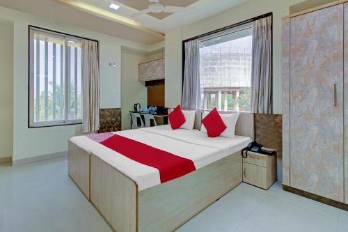 a bedroom with a large bed with red pillows at Happy Homely Stay Near Pune Airport in Khadki