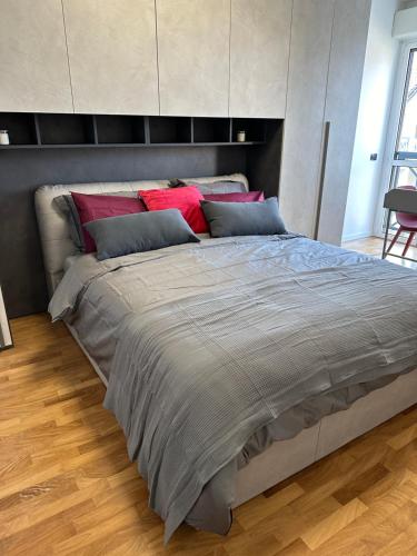 ein großes Bett mit roten Kissen im Schlafzimmer in der Unterkunft Deluxe Comfortable suite with balconie in Castellanza