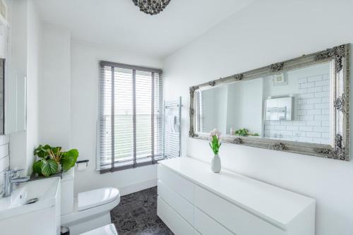 a white bathroom with a sink and a mirror at Peacefully set 2level 2BR btw Brixton & Camberwell in London