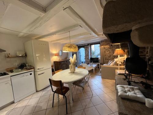 une cuisine et un salon avec une table et des chaises dans l'établissement Maison de pêcheur - Golfe du Morbihan, à Saint-Gildas-de-Rhuys