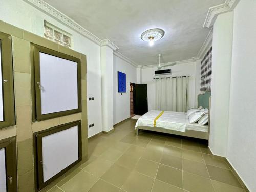 a bedroom with a bed and a door with a window at Luxe club des rois in Cotonou