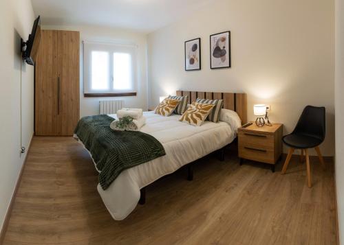 a bedroom with a bed and a chair and a window at Apartamento Larrazu Agroturismo Baztán in Arráyoz