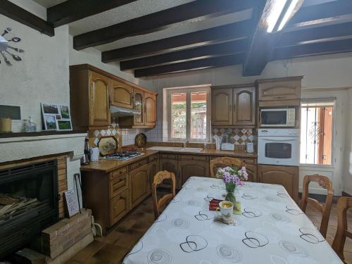 - une cuisine avec une table et des fleurs dans l'établissement Charmante maison de campagne avec jardin privatif, proche étangs et nature, idéale rando et vélo. - FR-1-591-80, à Rosnay