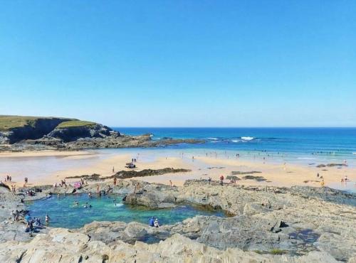 a group of people on a beach near the ocean at Heart of Kernow Holidays in Bugle