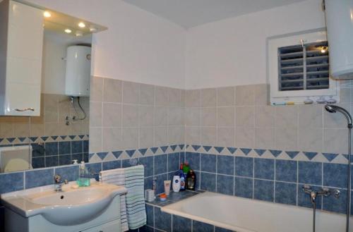 a bathroom with a sink and a bath tub at Nice View Apartment in Ivanica