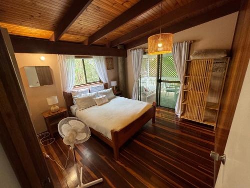 1 dormitorio con cama y ventana grande en Coconut Cottage Bush Retreat- Pet Friendly, en Tin Can Bay