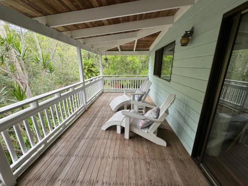dos sillas en el porche de una casa en Coconut Cottage Bush Retreat- Pet Friendly, en Tin Can Bay
