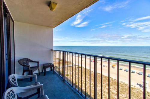 a balcony with chairs and a view of the beach at 0809 Carolina Shores by Atlantic Towers in Carolina Beach