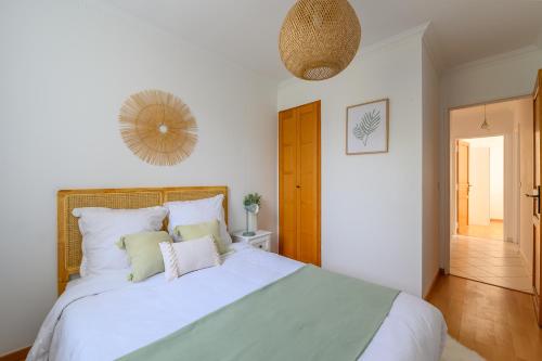 1 dormitorio con 1 cama blanca grande y espejo en Cœur de ville - Au pied du métro - 3 chambres, en Bobigny