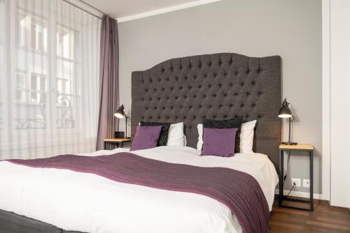 1 dormitorio con 1 cama grande con almohadas moradas en Boutique Hotel Weisses Kreuz - Adult only Hotel, en Lucerna