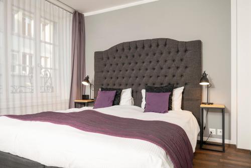 ein Schlafzimmer mit einem großen Bett mit lila Kissen in der Unterkunft Boutique Hotel Weisses Kreuz - Adult only Hotel in Luzern