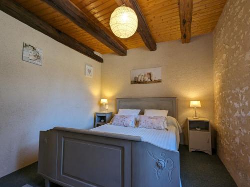 una camera da letto con un letto e una televisione di Maison de campagne avec jardin près d'Abbaye de Fontgombault et station thermale La Roche-Posay - FR-1-591-110 a Pouligny-Saint-Pierre
