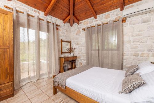 a bedroom with a bed and a stone wall at Sikia Holiday House in Kalamaki Zakynthos in Kalamaki