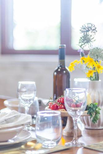 a table with wine glasses and a bottle of wine at Sikia Holiday House in Kalamaki Zakynthos in Kalamaki