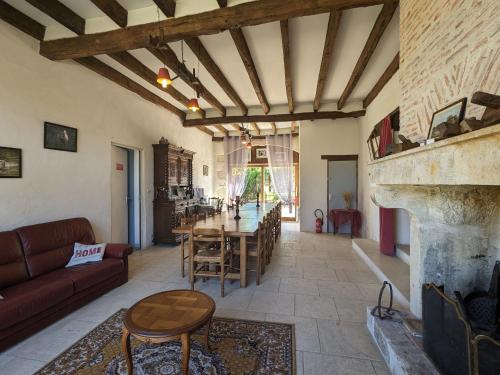 un salon avec une table et une cheminée dans l'établissement Domaine paisible au cœur du Berry, proche Parc de la Brenne, 6 chambres, cheminée, idéal familles - FR-1-591-200, à Mauvières