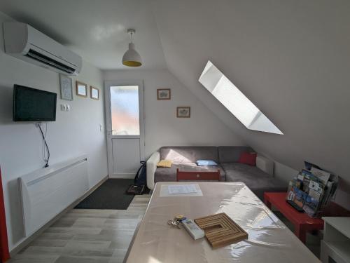 un salon avec un canapé et une table dans l'établissement Gîte chaleureux à 20min du Zoo de Beauval avec terrasse, climatisation et jeux extérieurs - FR-1-591-198, à Villentrois