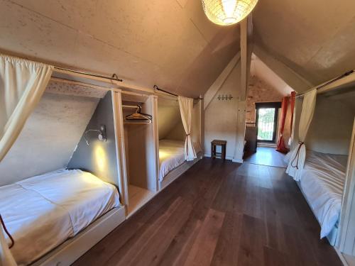 a room with two beds and a wooden floor at Maison avec jardin, piscine chauffée et baignade à proximité - Le Menoux - FR-1-591-234 in Le Menoux