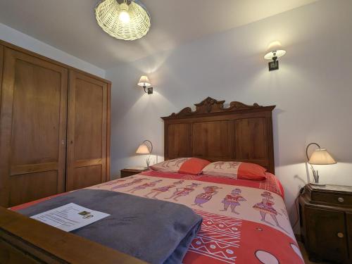 una camera da letto con un letto con testiera in legno di Charmant gîte rénové en Berry avec grand terrain, cheminée, et proximité UNESCO et thermes - FR-1-591-212 a Mauvières