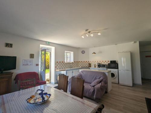 un salon avec une table et une cuisine dans l'établissement Charmant gîte rénové en Berry avec grand terrain, cheminée, et proximité UNESCO et thermes - FR-1-591-212, à Mauvières
