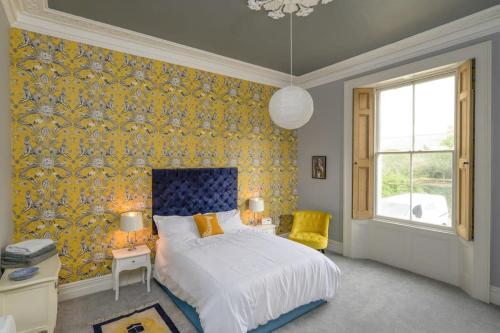 1 dormitorio con cama y papel pintado de color amarillo en Gorgeous Apartment Seconds from Seafront Clevedon, en Clevedon