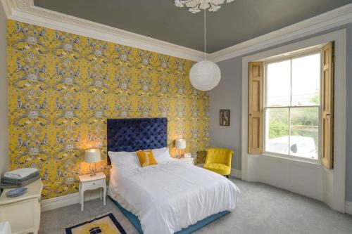 a bedroom with a bed and a yellow wallpaper at Gorgeous Apartment Seconds from Seafront Clevedon in Clevedon