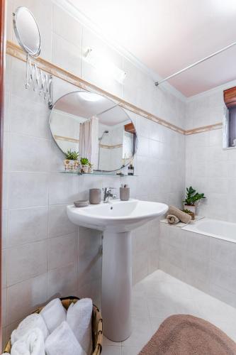 a bathroom with a sink and a mirror and a tub at Sikia Holiday House in Kalamaki Zakynthos in Kalamaki