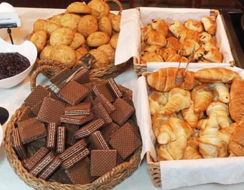 three baskets filled with different types of pastries on a table at Autopapa in Rustavi