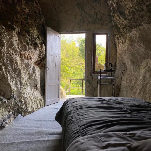 a bedroom with a bed and a door with a window at PALEO Stone Age in Karangwetan