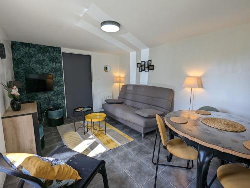 un salon avec un canapé et une table dans l'établissement Maison en Berry avec jardin clos et terrasse - draps et ménage inclus - FR-1-591-408, à Le Menoux