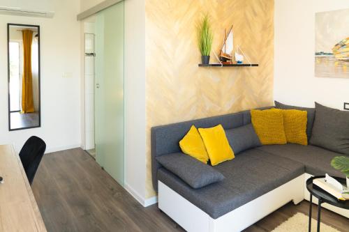 sala de estar con sofá gris y almohadas amarillas en B&B Spavalica en Vir