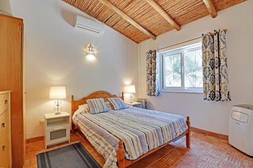 1 dormitorio con cama y ventana en VIVENDA ALGARVIA, en Bordeira