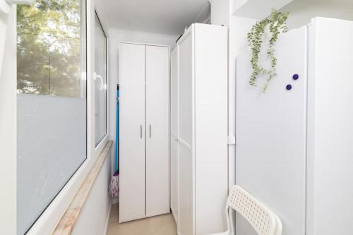 a hallway with white cabinets and a window at Modern 3 bedroom Flat in Lisbon in Lisbon