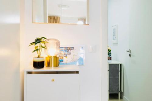 a table with a lamp and a plant on it at Modern 3 bedroom Flat in Lisbon in Lisbon