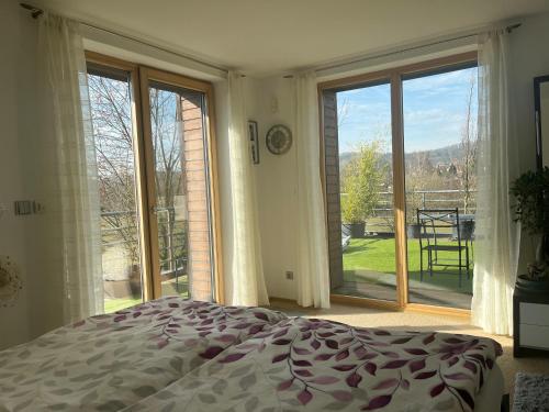 a bedroom with a bed in front of a large window at Apartmán s wellness službami in Čerčany