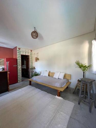 a bedroom with a bed and a table and a stool at Casa Bacuri in Porto Seguro