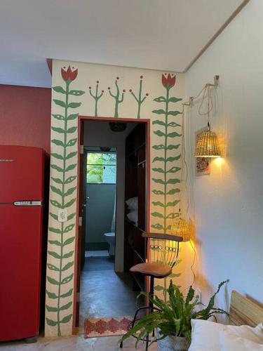 Habitación con un pasillo con una pared decorada con cactus. en Casa Bacuri, en Porto Seguro