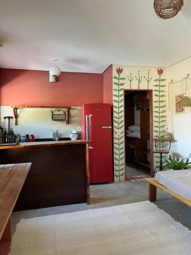 uma cozinha com um frigorífico vermelho num quarto em Casa Bacuri em Porto Seguro