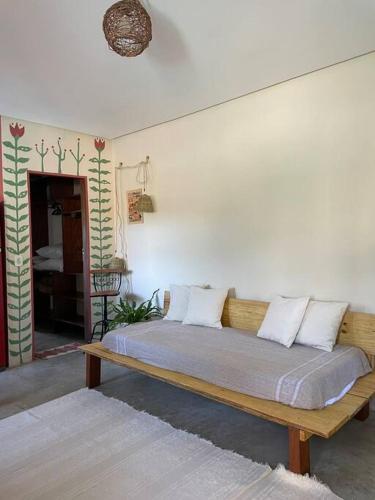 a bedroom with a wooden bed with white pillows at Casa Bacuri in Porto Seguro