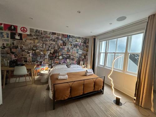 a bedroom with a bed and a wall covered in photos at Pop Art Luxury Room Marylebone in London